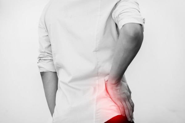 man holding his hip with hip pain - Hosford Health Clinic