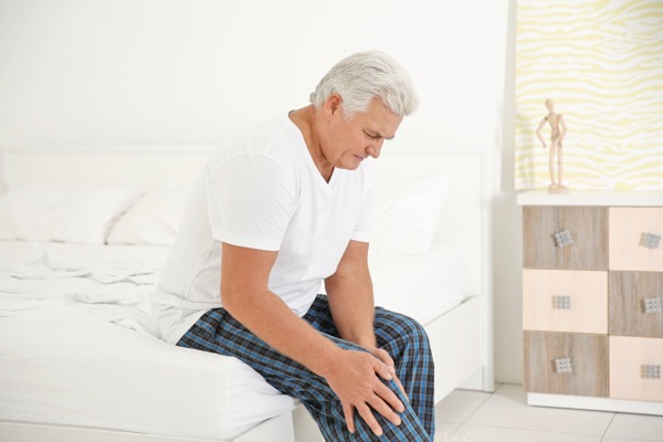 Senior man suffering from arthritis pain in his knee - Hosford Health Clinic