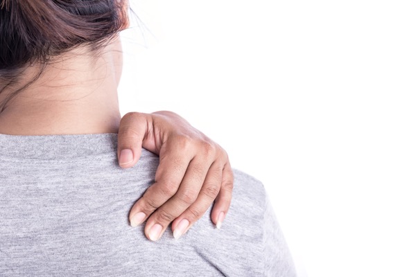Patient clasping shoulder with headache, neck and shoulder pain